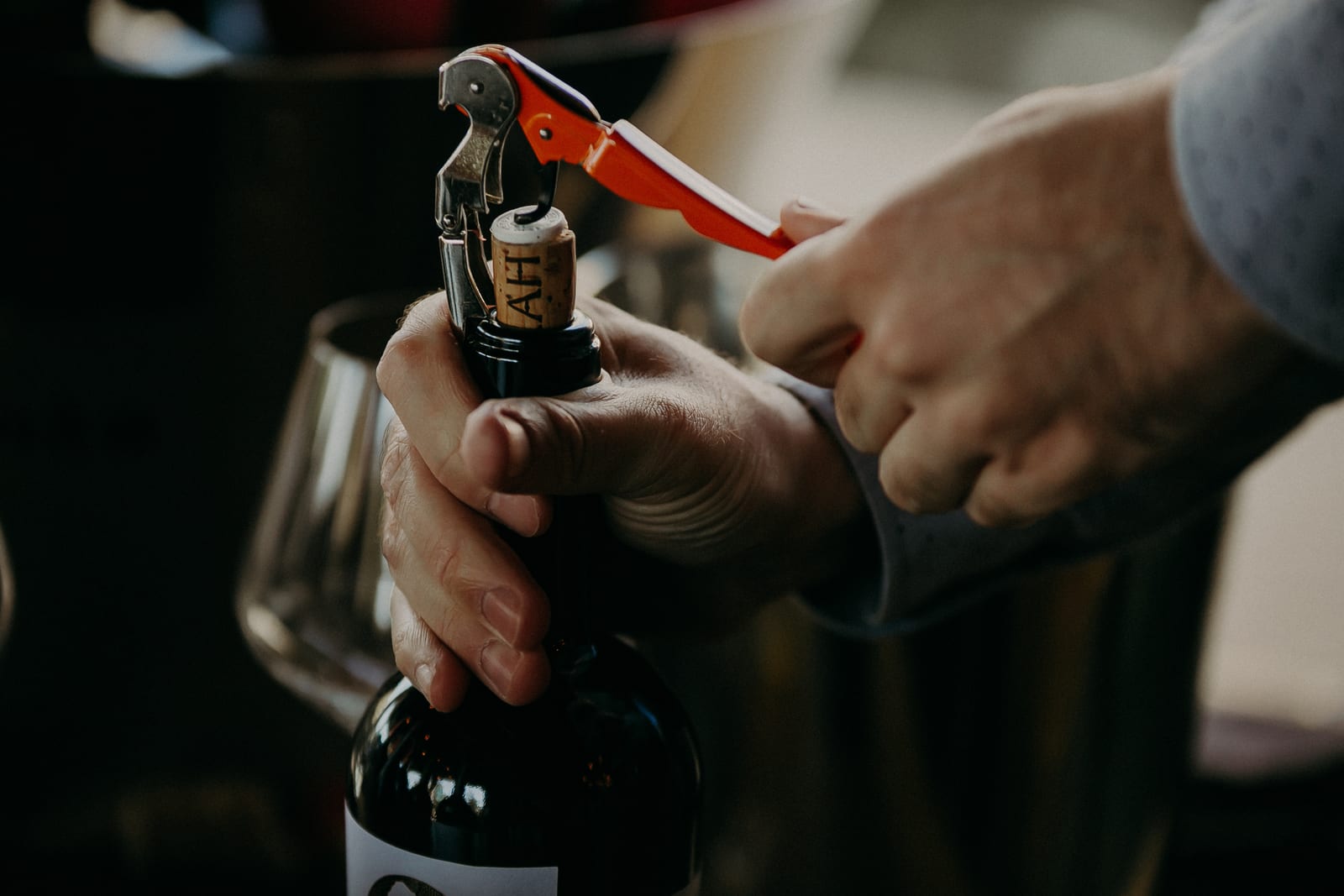 A bottle of wine opened at a quietly lit table