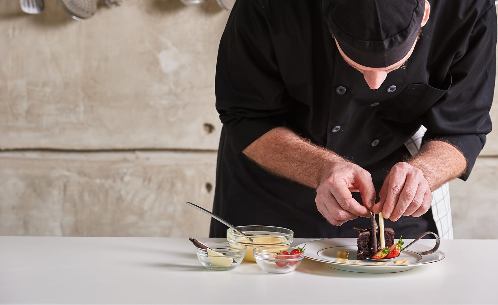A chef finishing a plated dessert